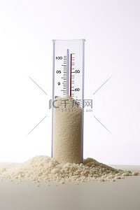 白色背景照片中沙子中的温度计