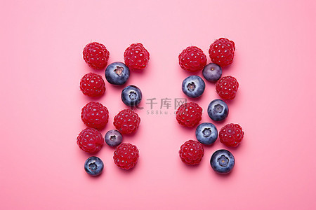 粉红色背景中五颜六色的覆盆子和蓝莓