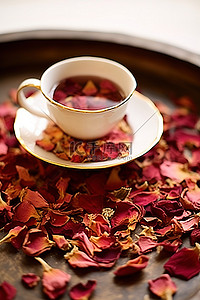 干玫瑰花瓣背景图片_盘子里放着一杯茶，上面有干玫瑰花瓣