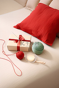 桌子上放着一个未完成的圣诞盒子，床上放着红纱