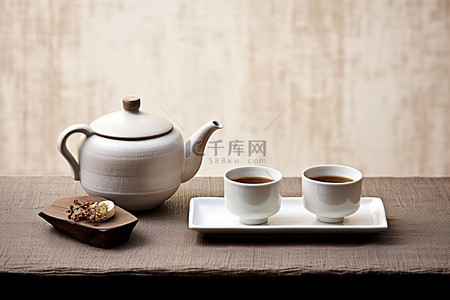 茶杯子背景图片_桌子上放着两个茶壶和一个杯子