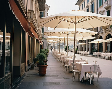 意大利街道背景图片_小街上有一家带桌子和遮阳伞的户外咖啡馆