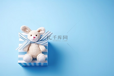 养老育儿背景图片_一只玩具兔子坐在蓝色背景的盒子里