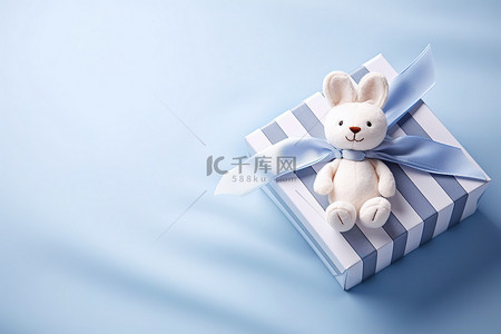 养老育儿背景图片_躺在蓝色盒子里的小毛绒动物，带蝴蝶结