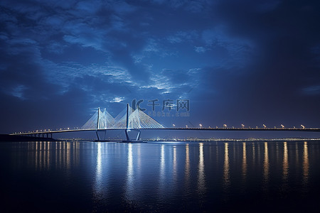 桥上布满灯光，照亮了夜晚的水面