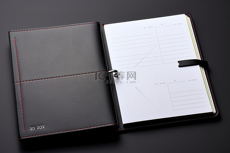 每周上新背景图片_灰色表面上的每周笔记本日历和办公桌记事本