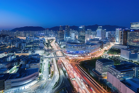 高速公路背景图片_首尔高速公路交叉口和路灯，左边有一条街道，有一些建筑物和摩天大楼