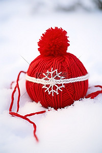 冬天温暖背景图片_红色羊毛针织球和坐在雪中的蝴蝶结