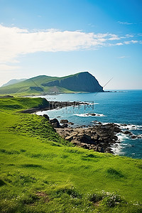蓝色的海洋背景图片_岛屿前景的绿草，身后是蓝色的海洋