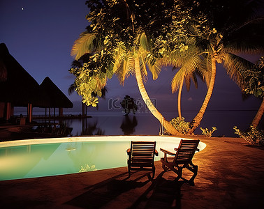 晚上的海背景图片_晚上有两把椅子和树木的热带度假村