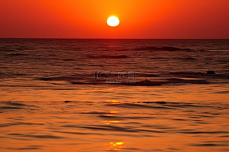 早晨的太阳背景图片_当太阳落在海洋上时，可以看到游泳者