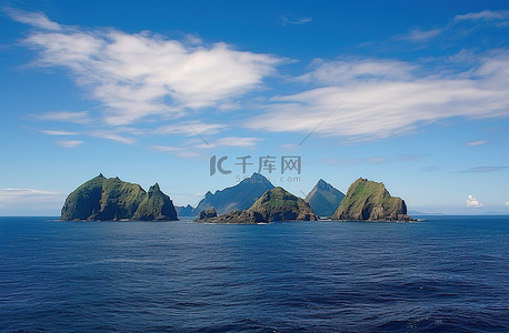蓝天海洋背景背景图片_海洋中的三个岛屿，有云彩蓝天和其他东西