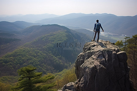一个人走在悬崖边观察山谷