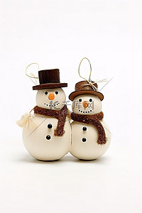 白色背景上的两个手工制作的雪人装饰品
