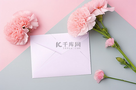 粉红色背景图片_粉红色康乃馨和灰色信封放在粉红色背景的中间