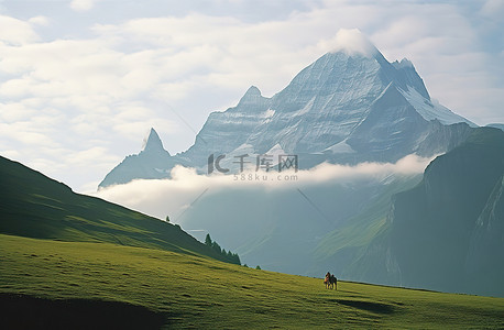 一个人骑马穿过山附近的草地