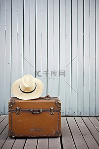 防寒帽子背景图片_一个手提箱和帽子坐在木板上