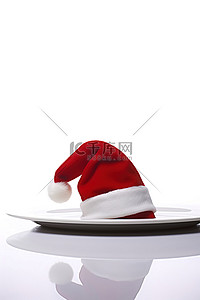 红色的圣诞老人帽子坐在白盘子上