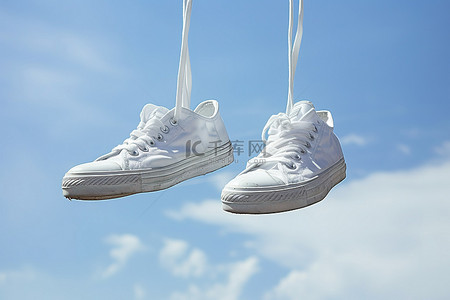 卫衣长袖白色背景图片_白色运动鞋挂在天空的绳子上