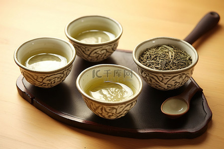 绿茶茶叶背景图片_五杯绿茶和勺子