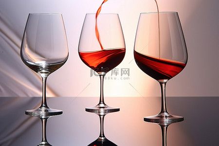 酒背景图片_三个装有酒的玻璃杯放在闪亮的表面上