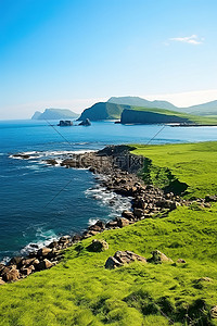 岛屿前景的绿草，身后是蓝色的海洋