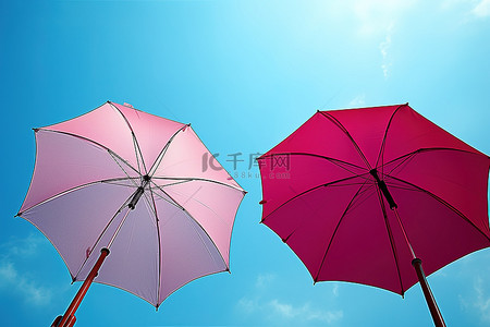 两把五颜六色的雨伞在蓝天上升起