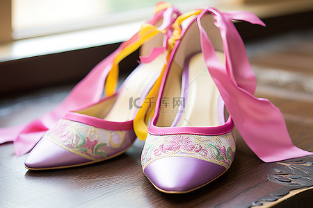 轻奢灰色鞋服背景图片_粉红色的婚礼鞋，配上一些紫色和黄色的丝带