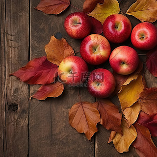 秋天背景图片_苹果和秋天的树叶在木背景上