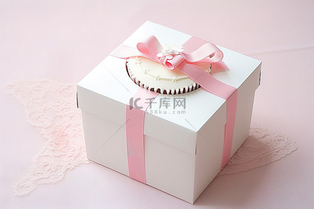 白色盒子里的白色蛋糕，上面系着粉红丝带