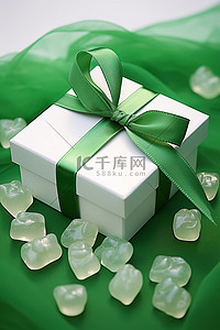 一个带有绿色丝带和白色小熊软糖的礼品盒