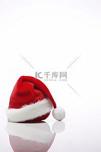 一顶红色的圣诞老人帽子，白色表面上有一个白色的球