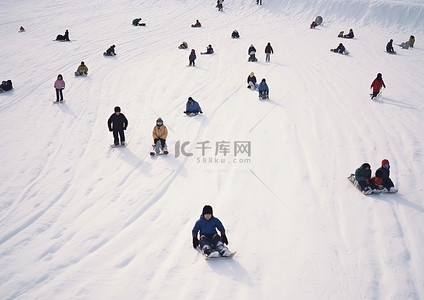 一群孩子乘雪橇滑下冰雪覆盖的山谷