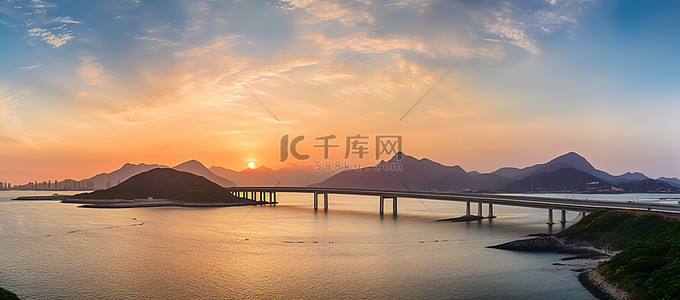 企业北景墙背景图片_香港华龙湾日落时海中的一座桥和山脉