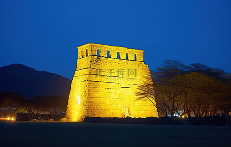 建筑废墟背景图片_一座巨大的石头建筑在夜间被点亮