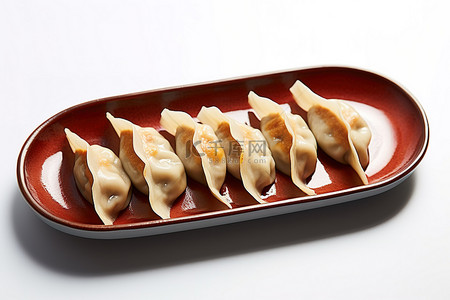 饺子背景图片_白墙前的酱汁盘上放着四个饺子