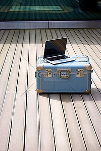木制甲板上装有笔记本电脑的行李箱