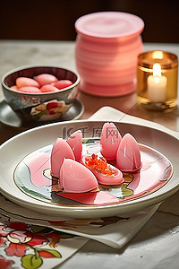 一盘食物旁边的桌子上放着一支粉红色的蜡烛
