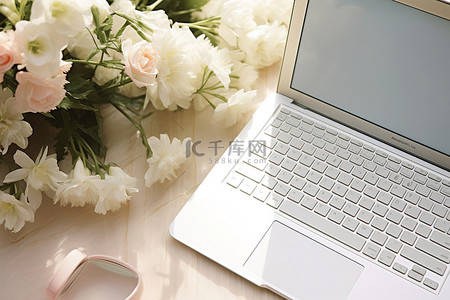 一台白色笔记本电脑，旁边放着鲜花
