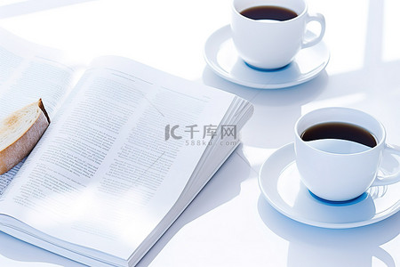 白色背景中，一杯咖啡旁边是报纸书籍和烤面包