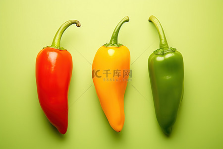 红绿辣椒背景图片_绿色背景中的三个辣椒
