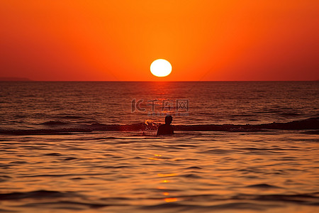 当太阳落在海洋上时，可以看到游泳者