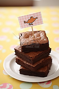 快乐蛋糕背景图片_一堆布朗尼蛋糕，上面贴着快乐纸杯蛋糕贴纸