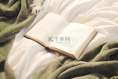 冬天温暖背景图片_床上毯子上一本打开的书