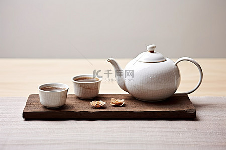 桌子上放着两个茶壶和一个杯子