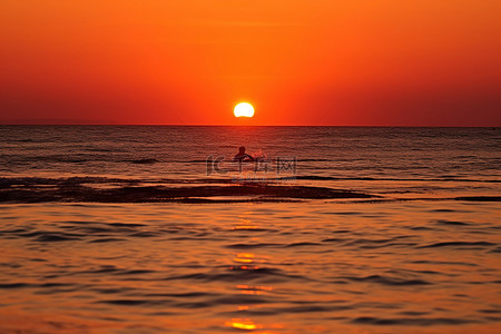 当太阳落在海洋上时，可以看到游泳者