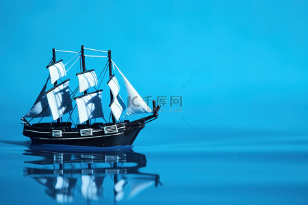 照片背景图片_一艘船帆漂浮在水面上的玩具船 照片