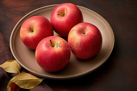 一盘四个红苹果和一张牛皮纸