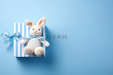 养老育儿背景图片_一只玩具兔子坐在蓝色背景的盒子里