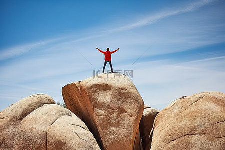 男人站在一块大石头上，双臂举在空中